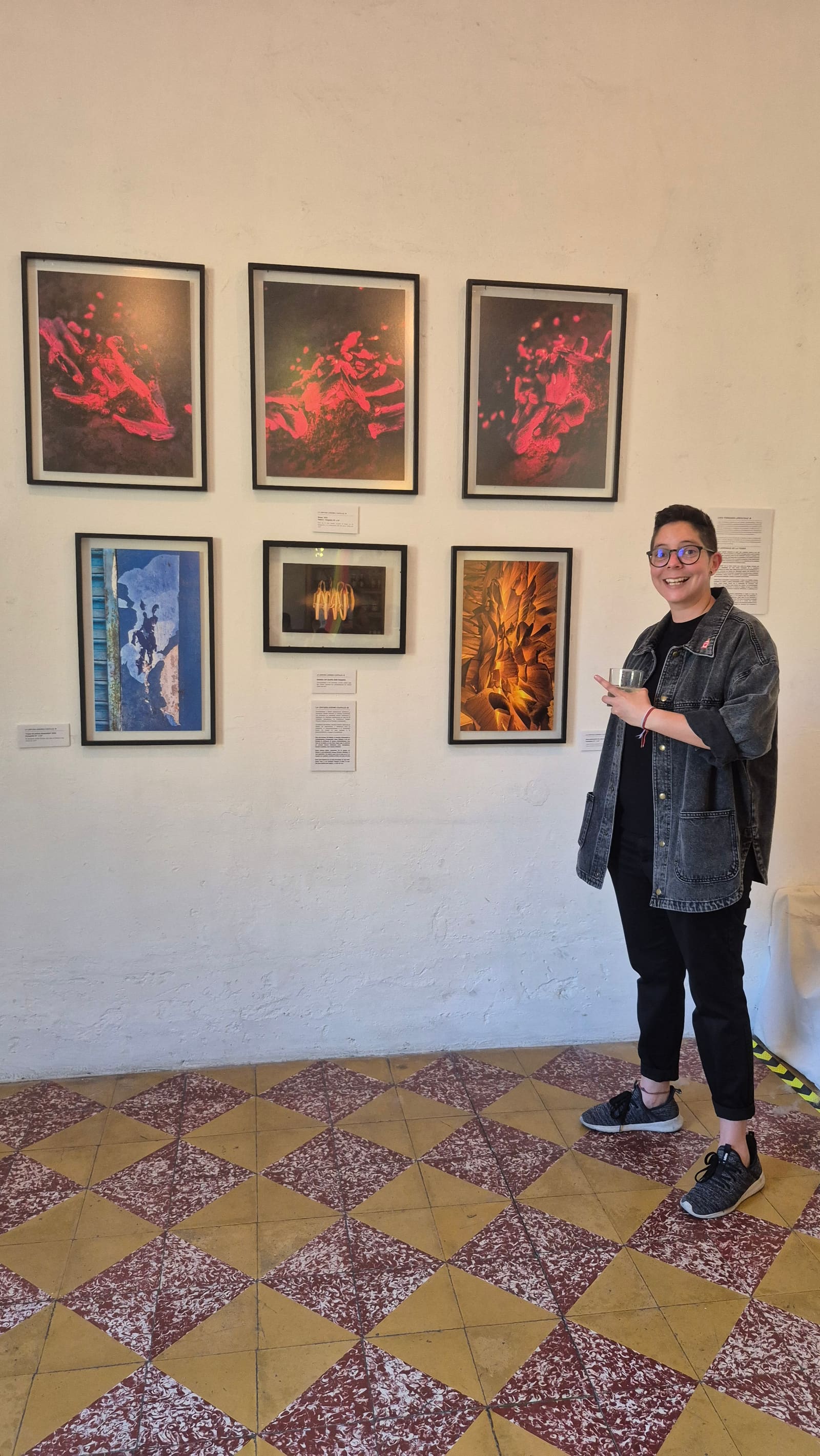 Andre in front of her six photographs on the wall at Red Materia